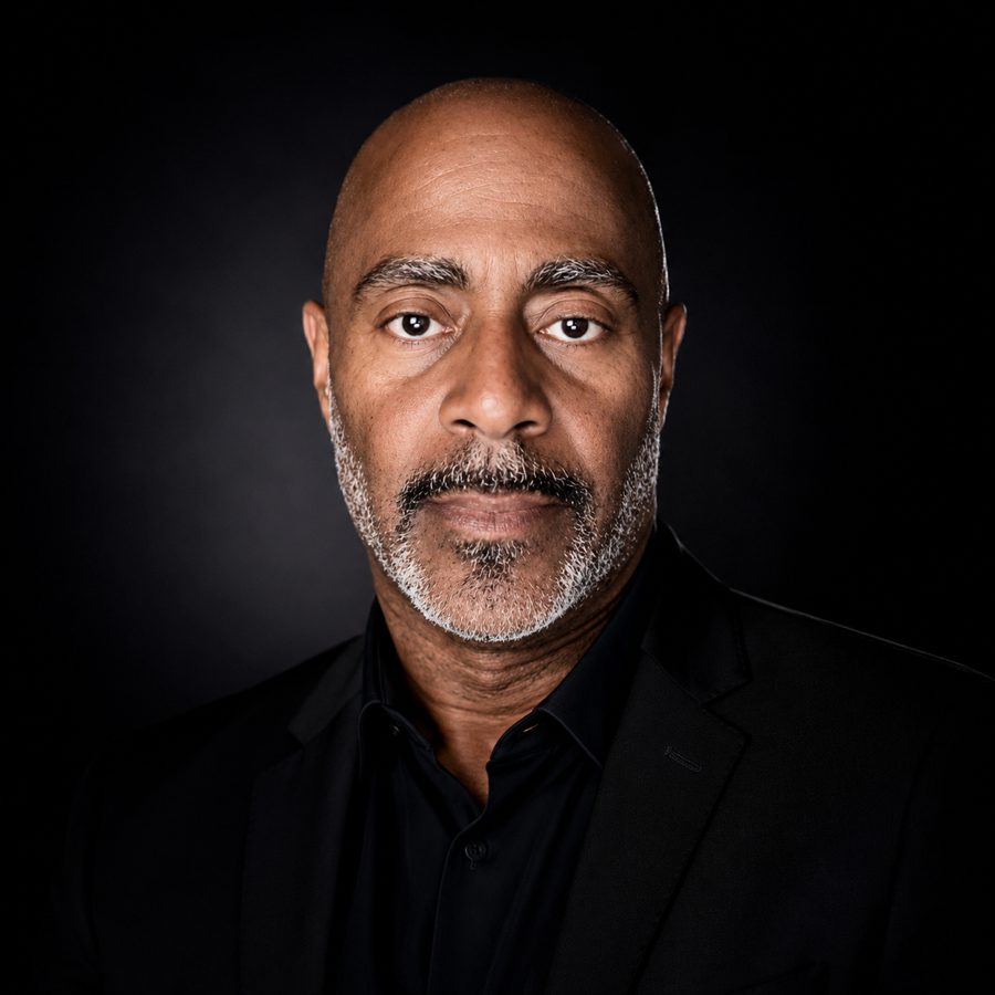 Todd Allyn in a black shirt and black sport coat against a black background